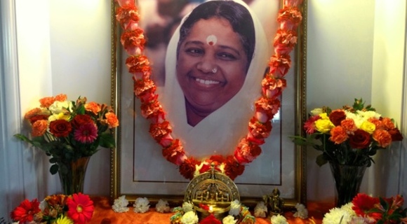 Amma's portrait on altar garlanded with fresh flowers