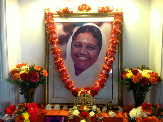 Amma's portrait on altar garlanded with fresh flowers