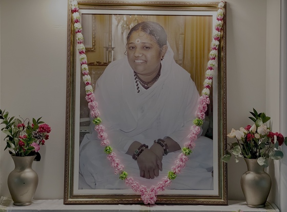 Amma's portrait on altar with garland and flowers