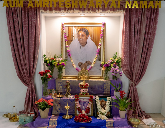 Altar with Amma's picture, garland and flowers