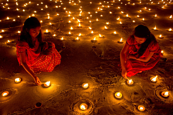 Girls lighting diwali lamps