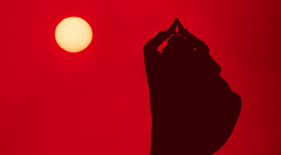 Amma silohette against a red sky with sun