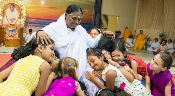 Amma surrounded by little girls hugging her