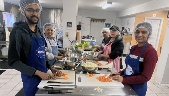 Volunteers chopping veggies for chilli in Amma Canada kitchen