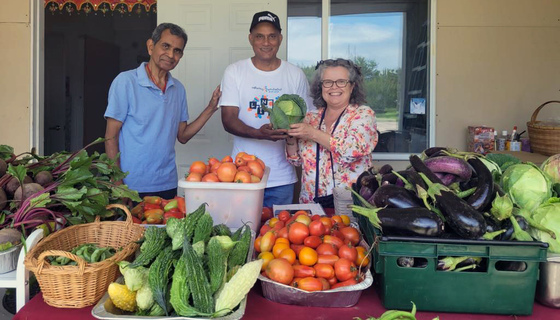 Volunteers at veggie sales stall with a bountiful harvest from the veggie garden