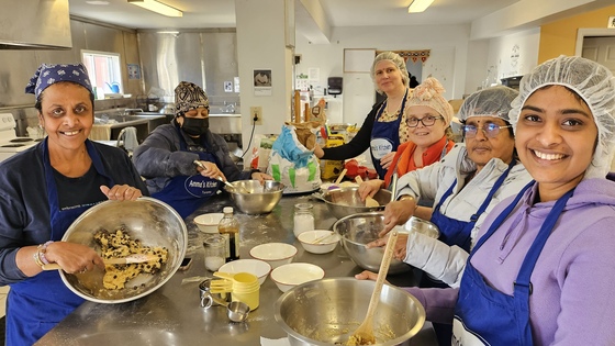 Volunteers baking chocolate chip cookies in Amma Canada kitchen