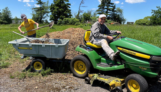 Volunteers moving wood chips with the tractor