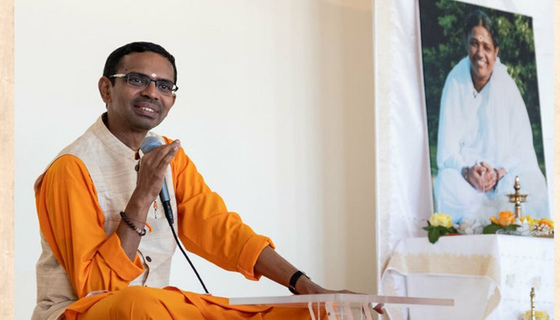 Shubhamrita Swamiji in front of a photo of Amma