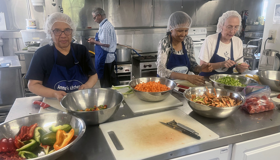 Volunteers chopping veggies for chilli in Amma Canada kitchen