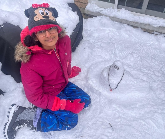 Child next to Siva Lingam they made out of snow garlanded with a rudraksha mala