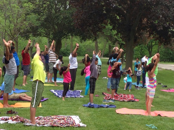 Kids and adults doing yoga together outdoors