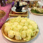 White roses on a dish before black stone Shiva Lingam