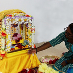 Young woman rocking baby Krishna's cradle