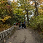 AYUDH volunteers walking down dirt road under autumn trees