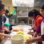Youth and mentor chopping fruits and washing dishes