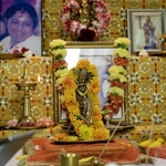 Krishna murti and Amma's photos with fresh flower garlands