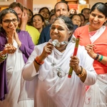 Amma with the dancers' hand cymbals while leaving crowd smiling