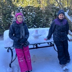 Two children next to a Siva Lingam they made out of snow