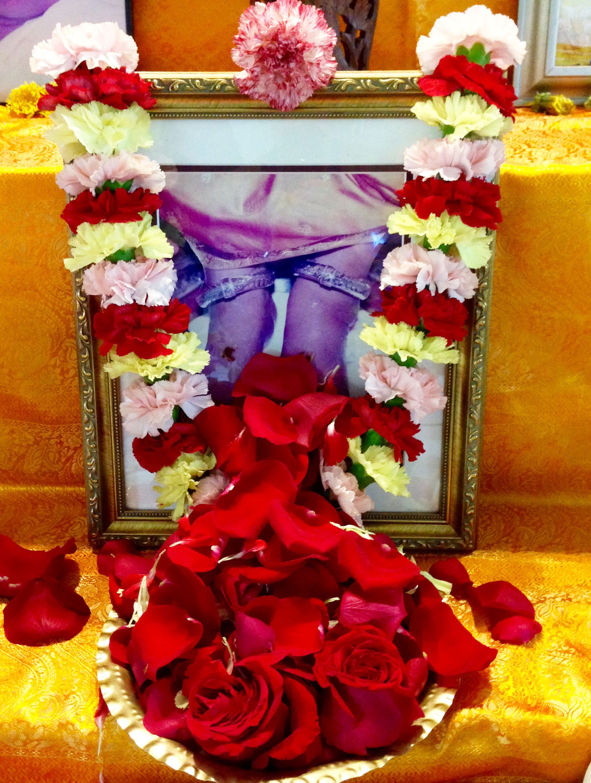 Amma's feet covered in red rose petals