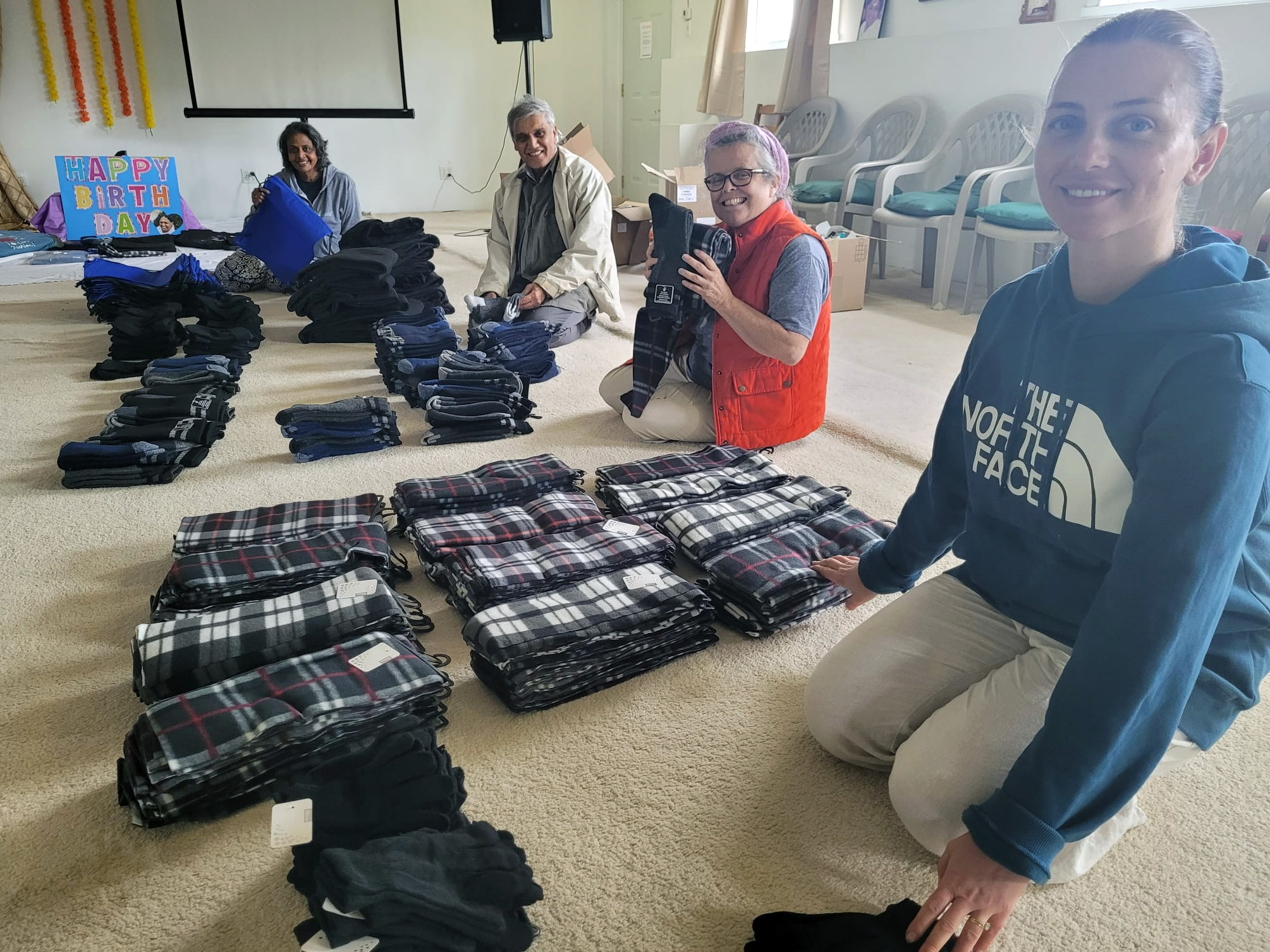 Volunteers packing warm socks, gloves, and toques into care packages for homeless people