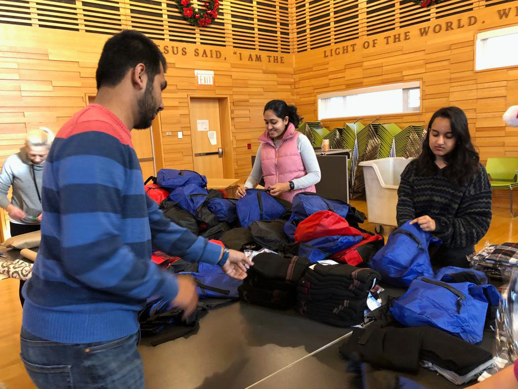 Youth packing backpacks for those in need