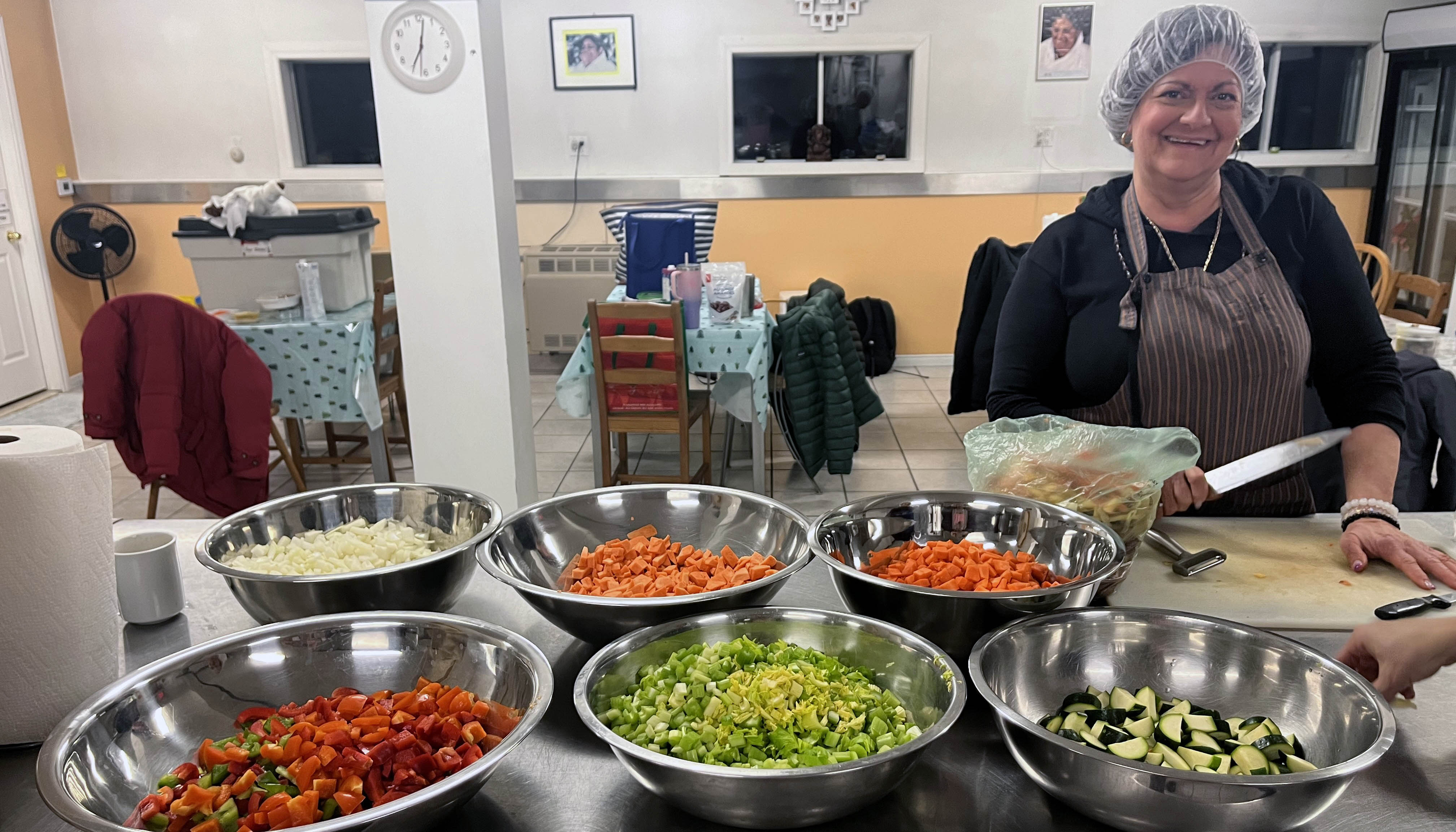 Volunteer with bowls of chopped veggies for chilli