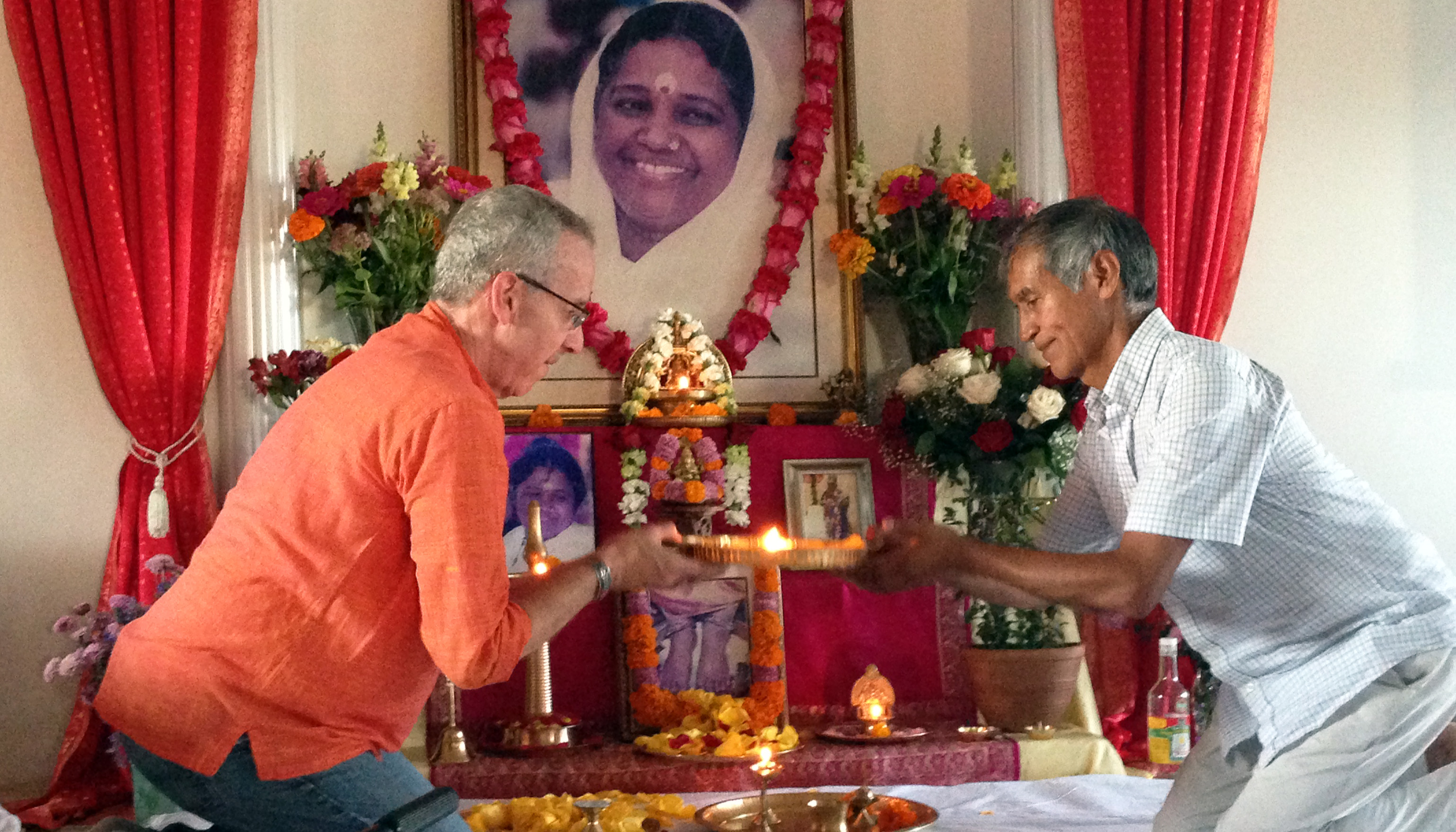 Devotees doing arati to beautiful altar with Amma's picture
